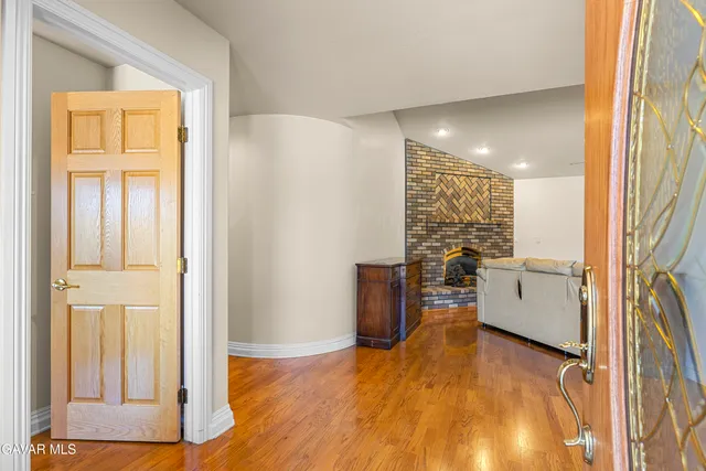 a view of a kitchen with a fridge and wooden floor