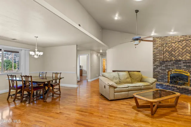 a living room with furniture a dining table and a fireplace