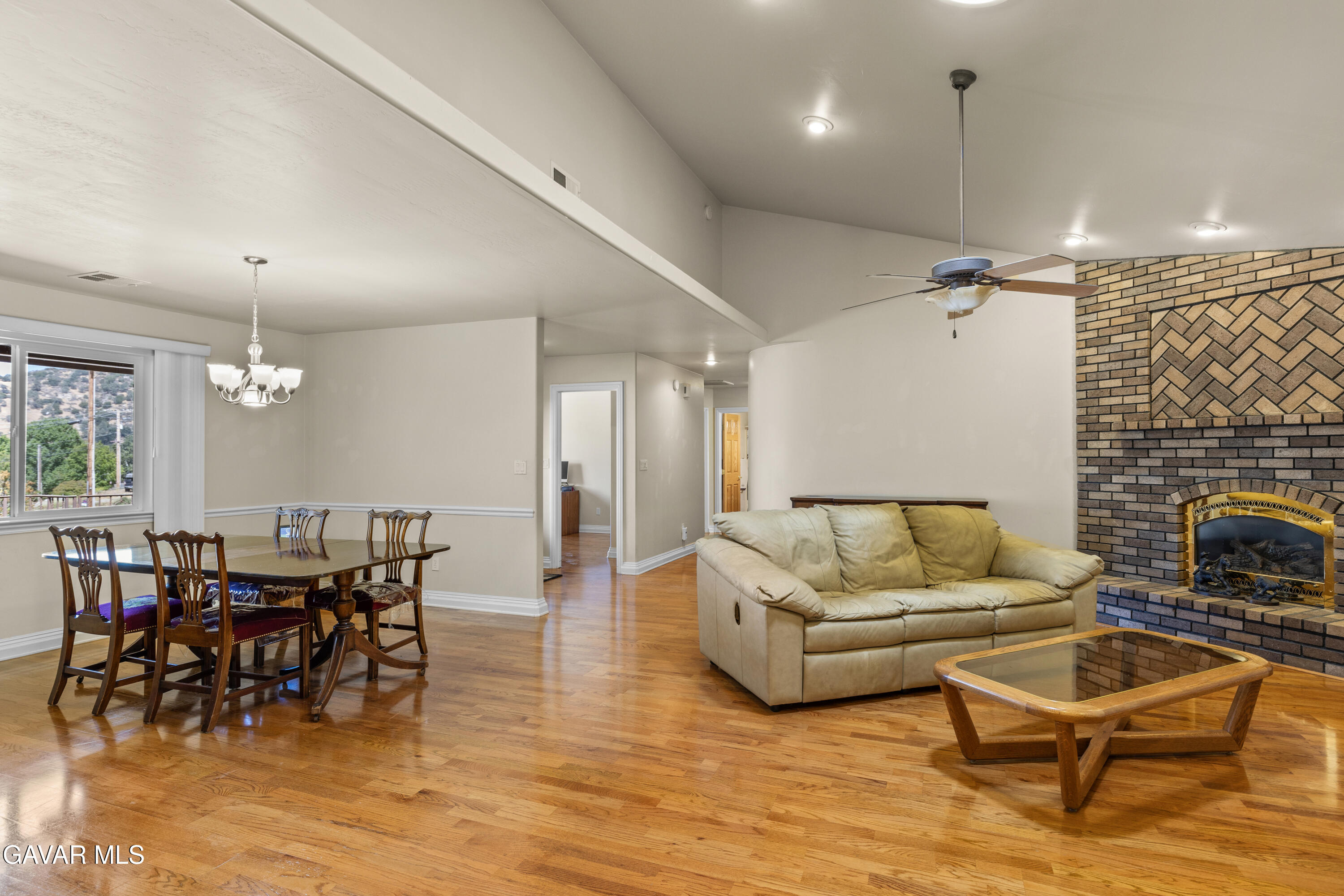 30100 Sunland Way Tehachapi, CA 93561 - Photo 6 of 44 a living room with furniture a dining table and a fireplace