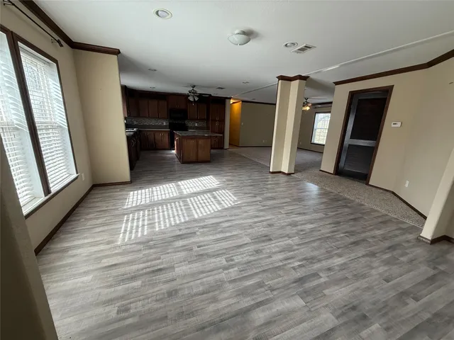 a view of empty room with wooden floor and furniture