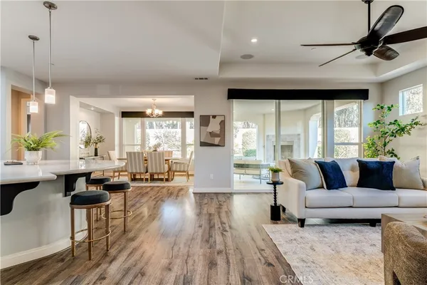 a kitchen with stainless steel appliances granite countertop a sink a stove a refrigerator and chairs