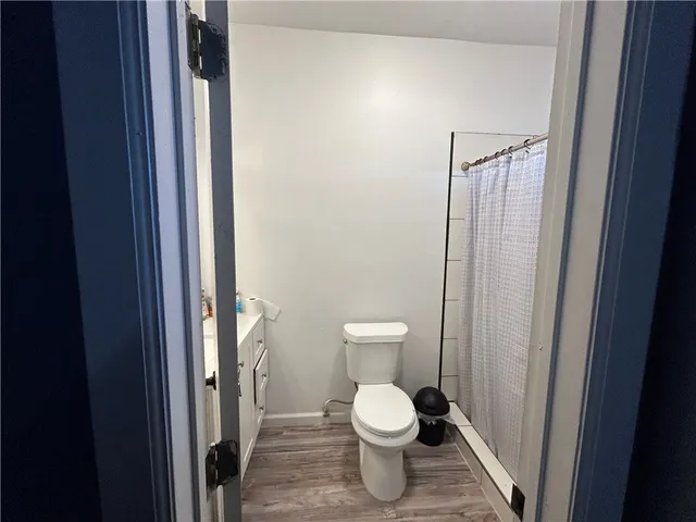 a white toilet sitting next to a shower