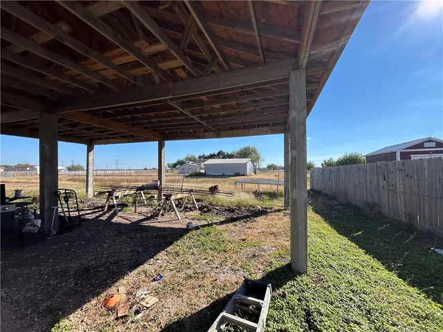 a view of a swimming pool with a table and chairs under an umbrella