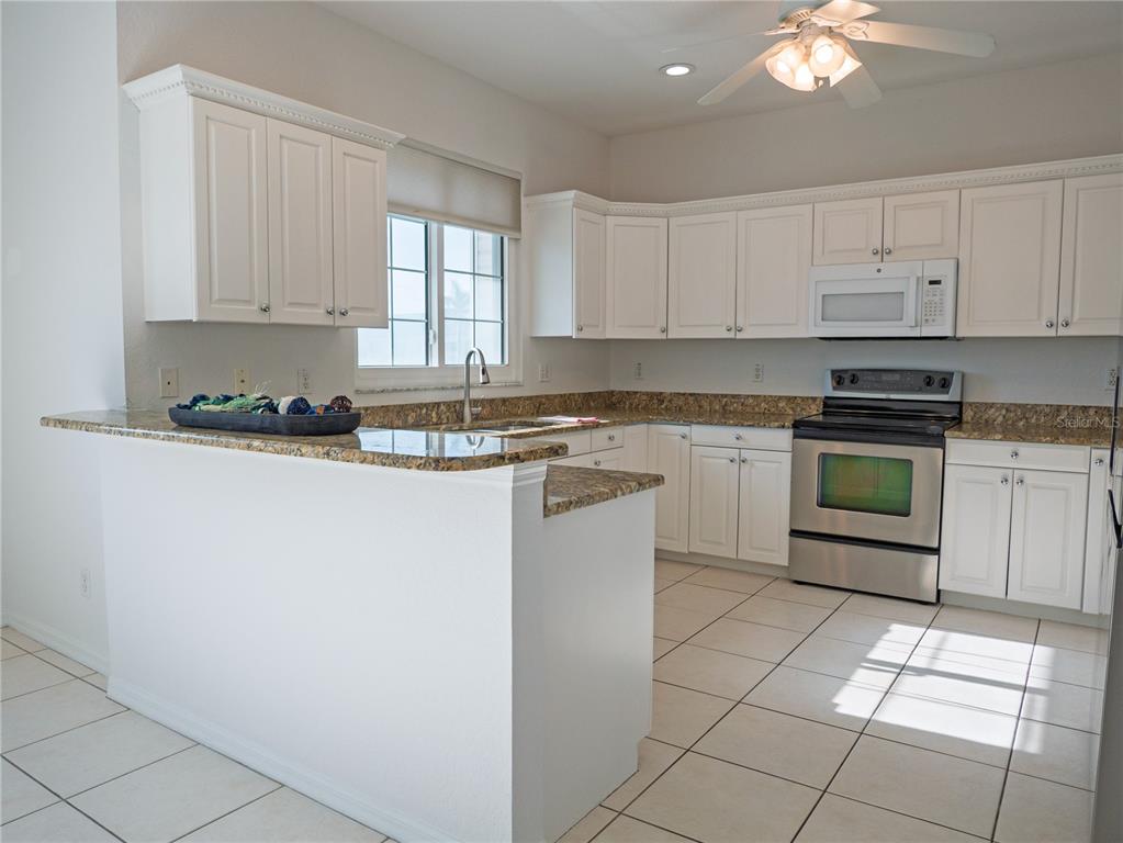 15473 Gulf Boulevard Madeira Beach, FL 33708 - Photo 12 of 41 a kitchen with a stove sink and cabinets