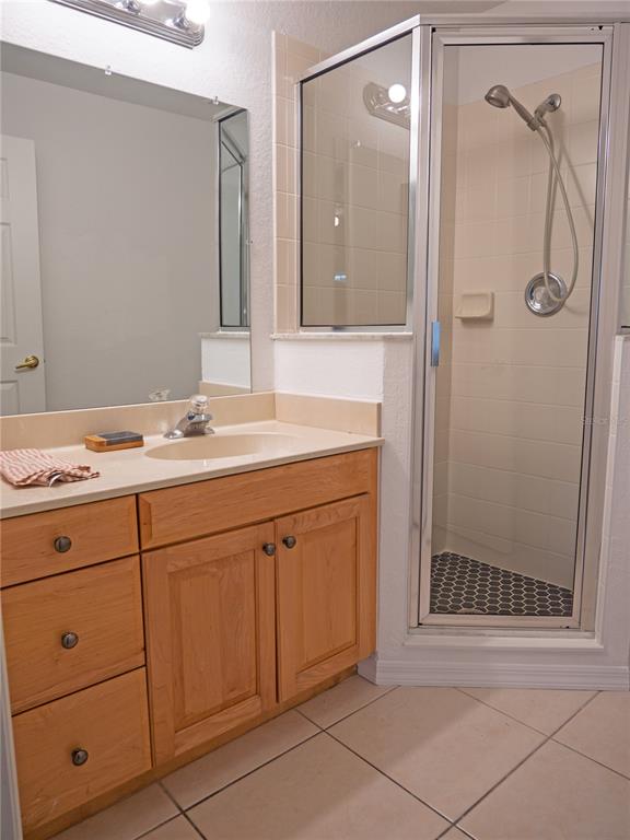 15473 Gulf Boulevard Madeira Beach, FL 33708 - Photo 26 of 40 a bathroom with a shower sink and mirror