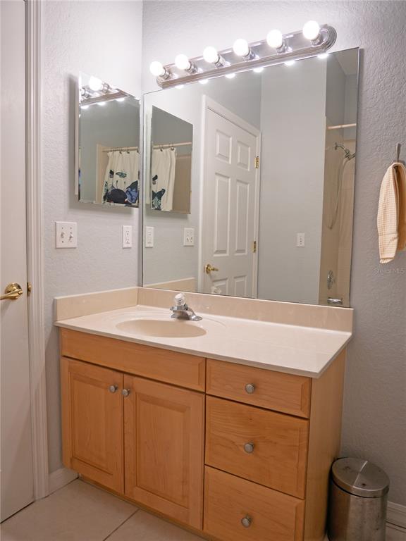 15473 Gulf Boulevard Madeira Beach, FL 33708 - Photo 29 of 41 a bathroom with a sink vanity and mirror