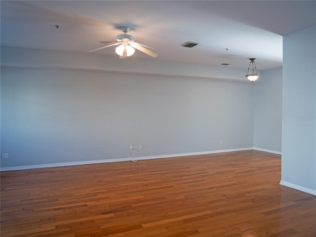15473 Gulf Boulevard Madeira Beach, FL 33708 - Photo 7 of 40 a view of an empty room with wooden floor and a ceiling fan