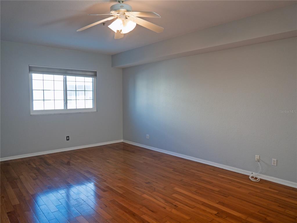 15473 Gulf Boulevard Madeira Beach, FL 33708 - Photo 9 of 41 an empty room with wooden floor and windows