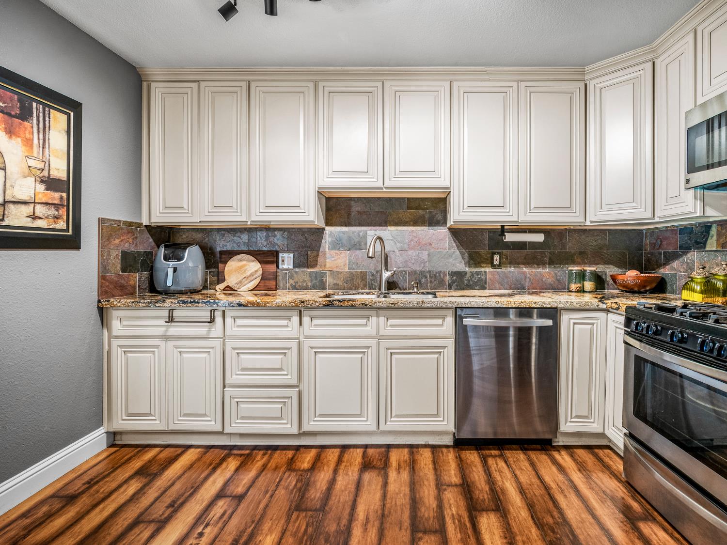 5324 Garfield Avenue, Unit 3 Sacramento, CA 95841 - Photo 10 of 17 a kitchen with granite countertop wooden cabinets and white appliances