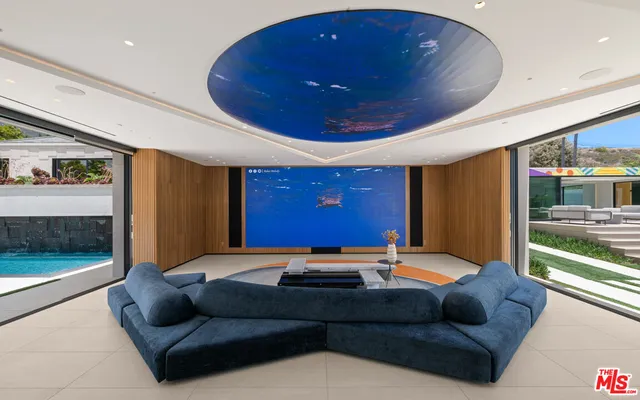 a living room with furniture a floor to ceiling window and a potted plant