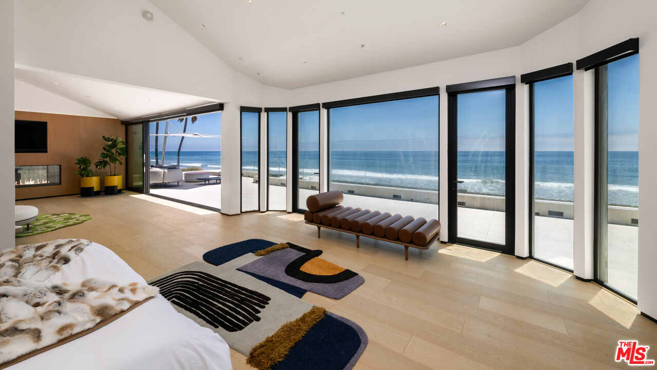 31100 Broad Beach Road Malibu, CA 90265 - Photo 15 of 38 a bedroom with furniture and large windows
