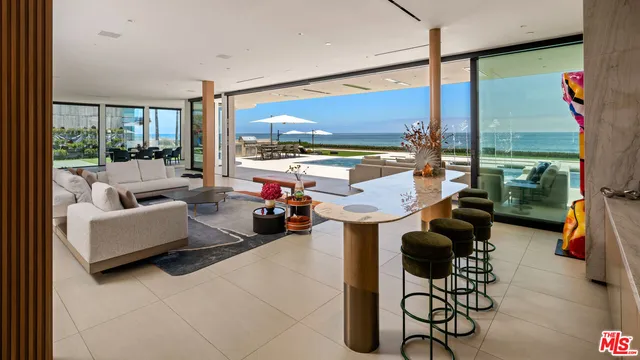 a living room with furniture a flat screen tv and kitchen view