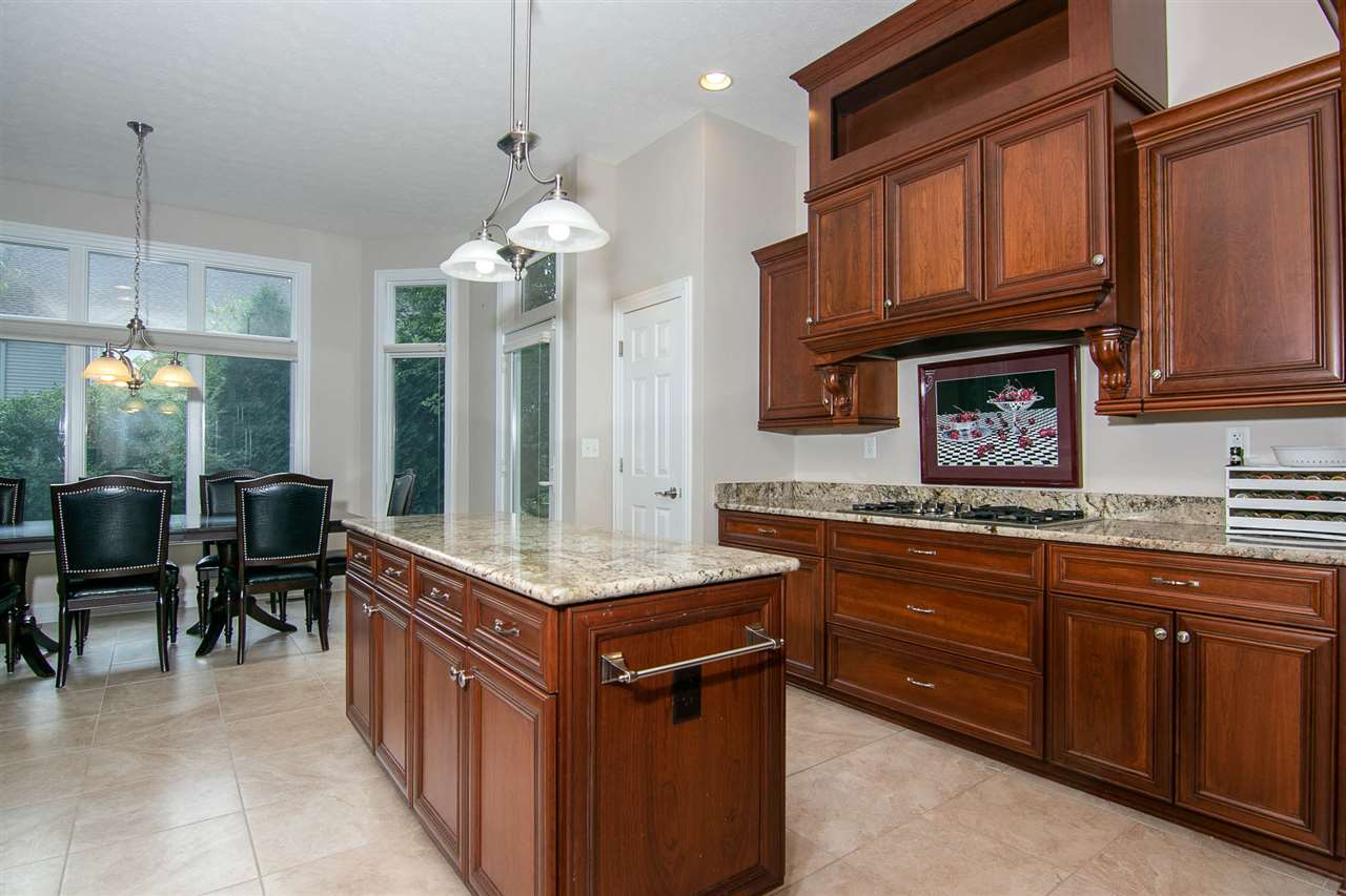 637 Roxbury Road Rockford, IL 61107 - Photo 5 of 25 a kitchen with kitchen island granite countertop a stove top oven a sink dishwasher a dining table and chairs with wooden floor