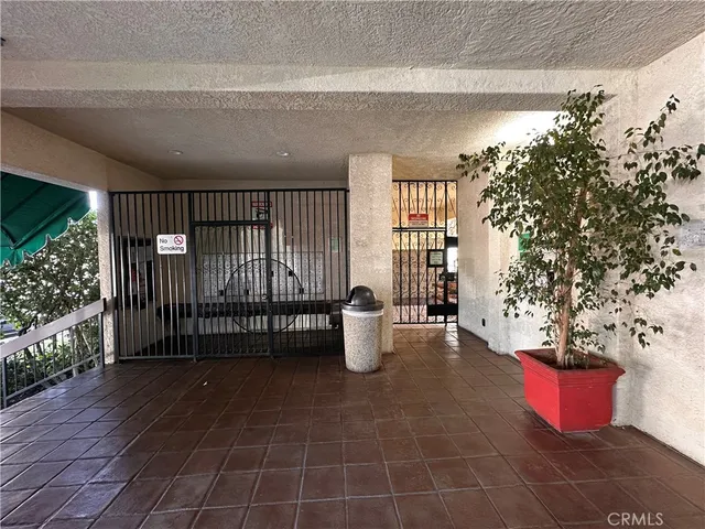 a view of a porch with chairs and potted plants