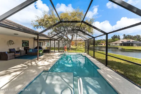a view of a swimming pool with a chair and tables in the patio