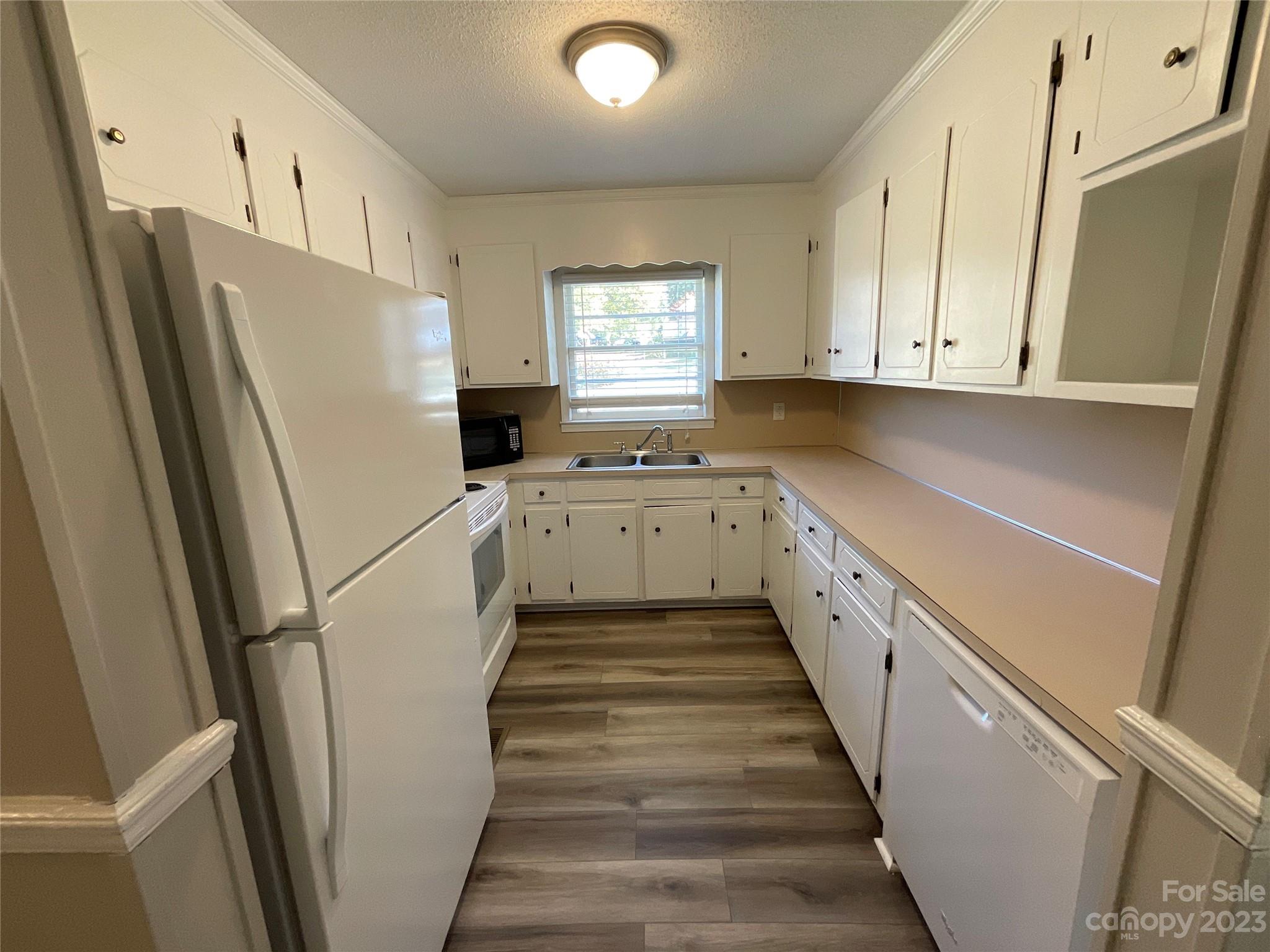 1285 Rainbow Circle Catawba, SC 29704 - Photo 8 of 22 a kitchen with granite countertop a refrigerator a sink a stove and white cabinets