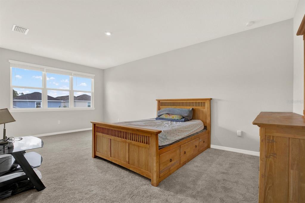 13729 Rangeland Boulevard Odessa, FL 33556 - Photo 18 of 30 a bedroom with a bed and a window