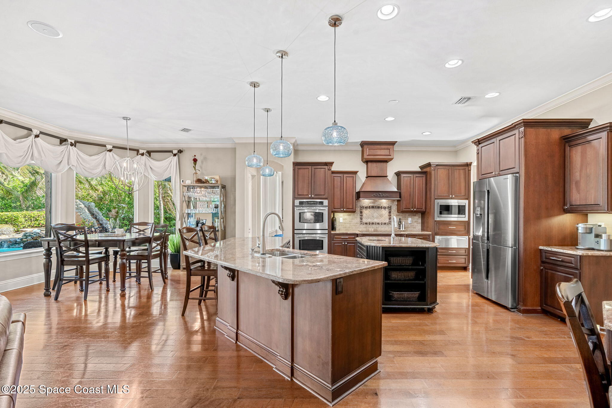 4297 Crooked Mile Road Merritt Island, FL 32952 - Photo 25 of 118 a kitchen with stainless steel appliances kitchen island granite countertop a table chairs stove and kitchen island