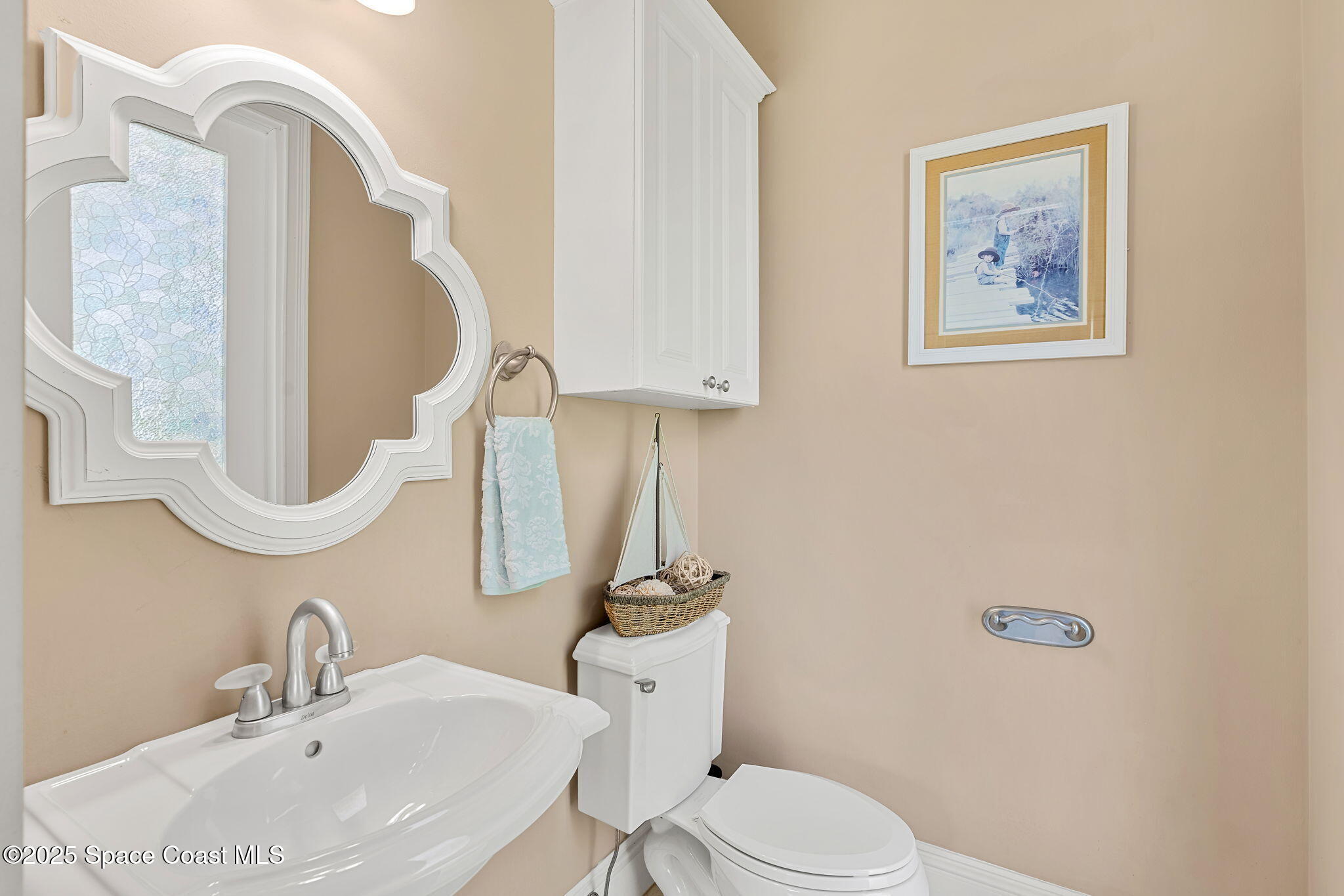 4297 Crooked Mile Road Merritt Island, FL 32952 - Photo 34 of 118 a bathroom with a toilet sink and mirror