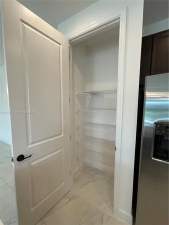a view of an empty room with window and cabinet