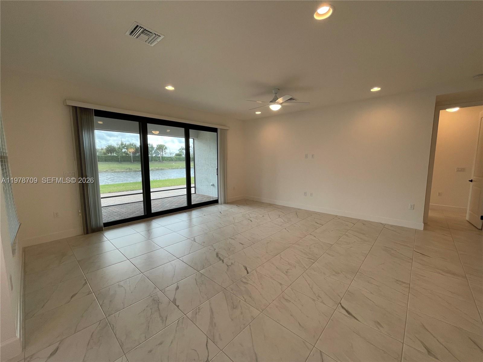 10922 Southwest Meandering Mile Road, Unit 10922 Port St. Lucie, FL 34987 - Photo 15 of 56 a view of an empty room with wooden floor and windows