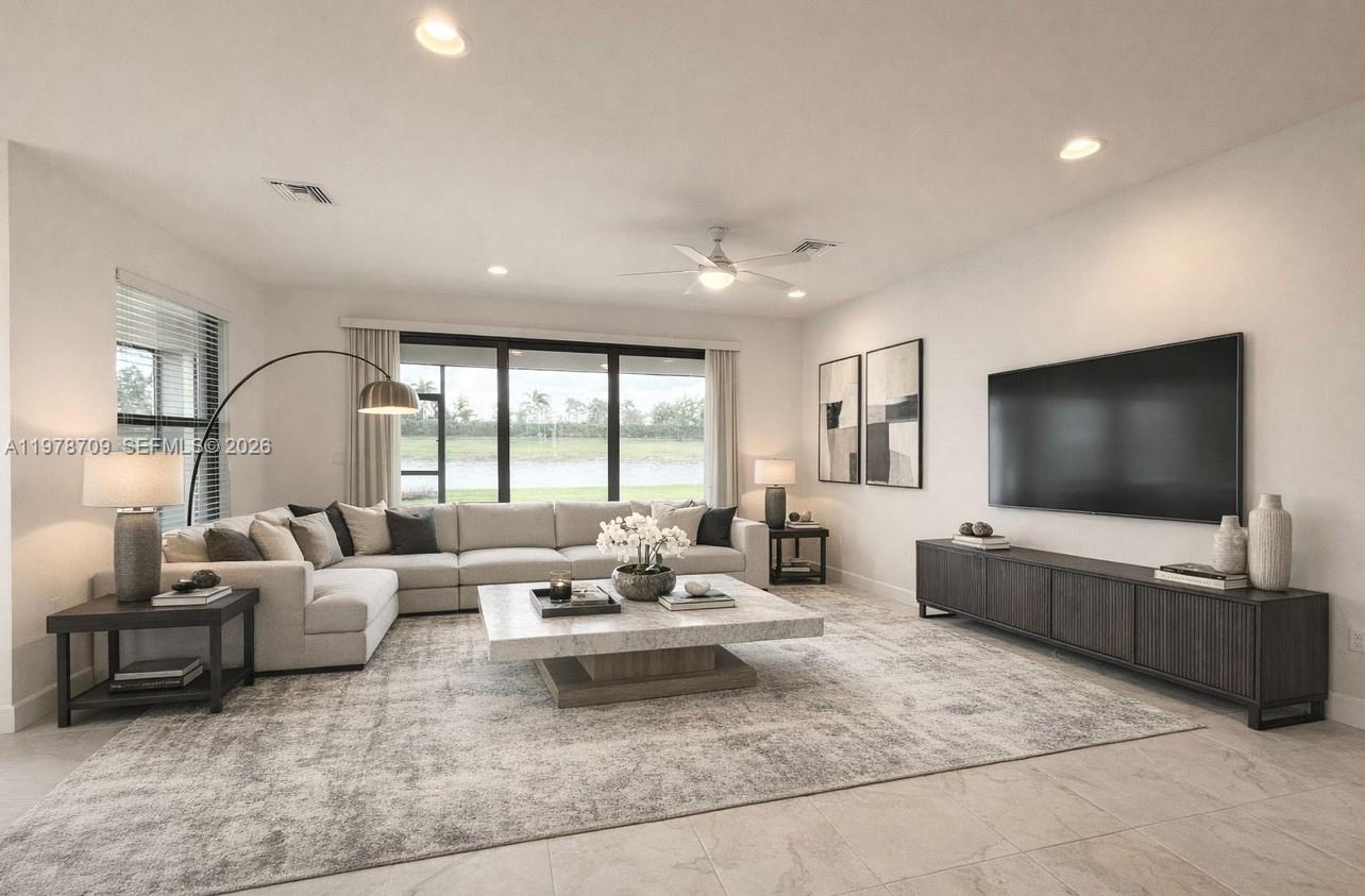 10922 Southwest Meandering Mile Road, Unit 10922 Port St. Lucie, FL 34987 - Photo 17 of 56 a living room with furniture and a flat screen tv