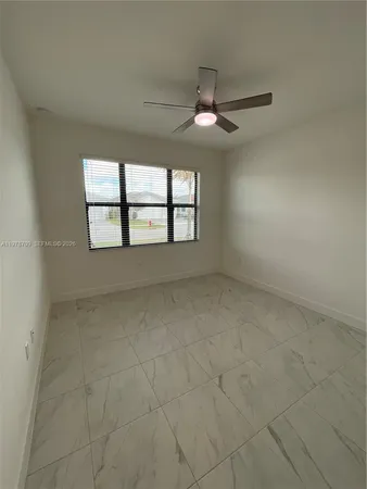 an empty room with a ceiling fan and a window