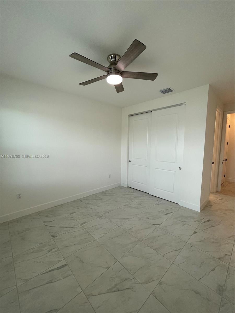 10922 Southwest Meandering Mile Road, Unit 10922 Port St. Lucie, FL 34987 - Photo 21 of 56 an empty room with a ceiling fan and a window
