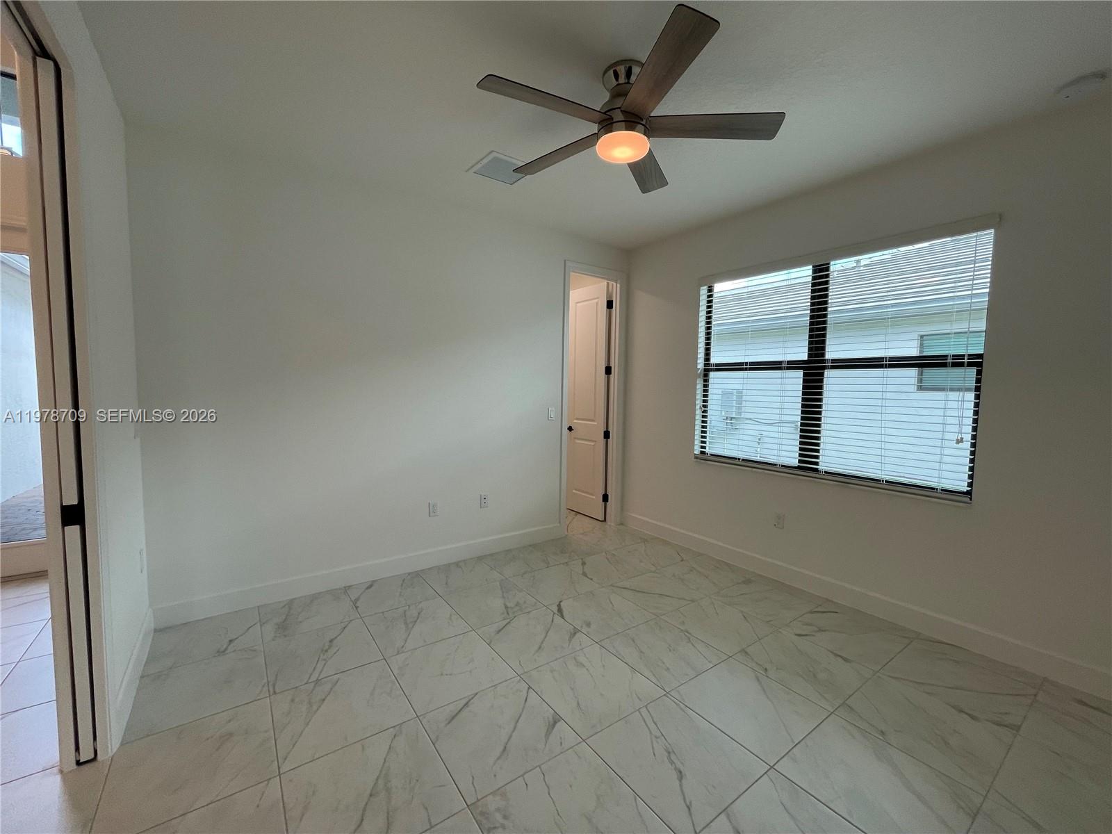 10922 Southwest Meandering Mile Road, Unit 10922 Port St. Lucie, FL 34987 - Photo 24 of 56 an empty room with windows and fan