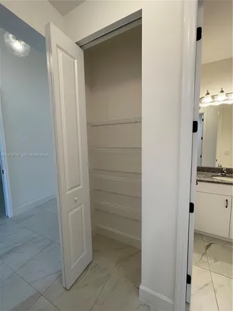 an empty room with a chandelier fan and windows