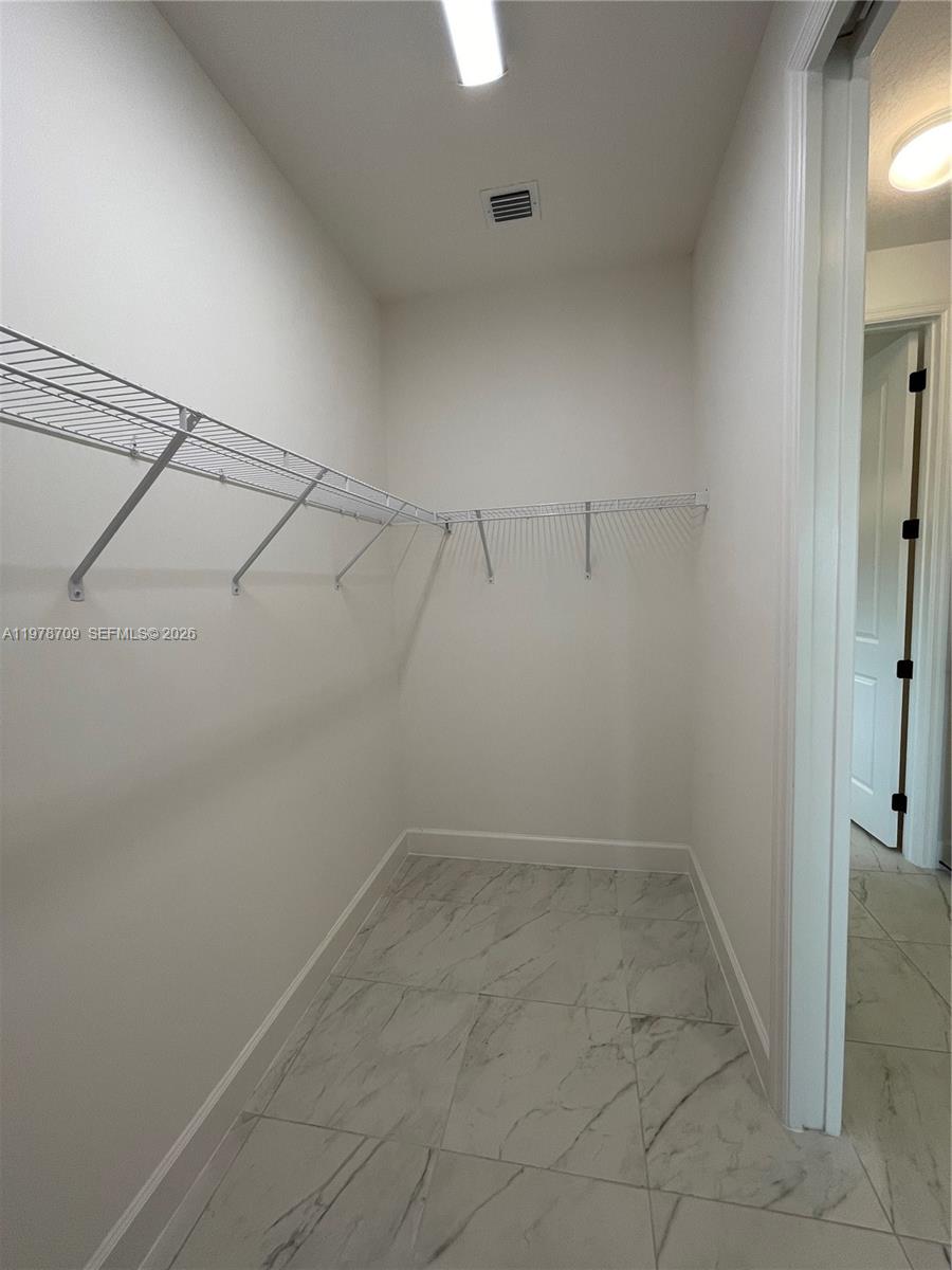 10922 Southwest Meandering Mile Road, Unit 10922 Port St. Lucie, FL 34987 - Photo 31 of 56 a view of a room with racks on the wall