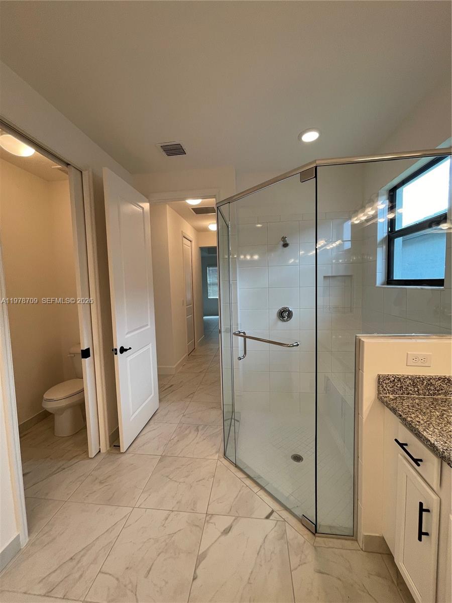 10922 Southwest Meandering Mile Road, Unit 10922 Port St. Lucie, FL 34987 - Photo 35 of 56 a bathroom with a glass shower door and a sink