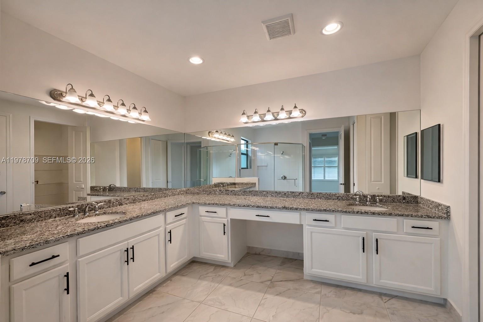 10922 Southwest Meandering Mile Road, Unit 10922 Port St. Lucie, FL 34987 - Photo 36 of 56 a large bathroom with a sink and a large mirror
