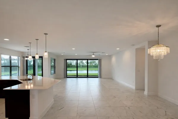 a open kitchen with stainless steel appliances granite countertop a refrigerator a sink a oven and a large window