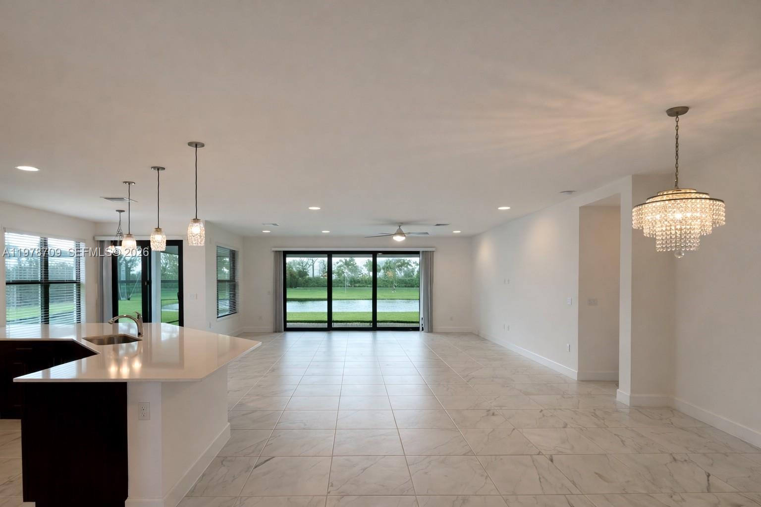 10922 Southwest Meandering Mile Road, Unit 10922 Port St. Lucie, FL 34987 - Photo 5 of 56 a open kitchen with stainless steel appliances granite countertop a refrigerator a sink a oven and a large window