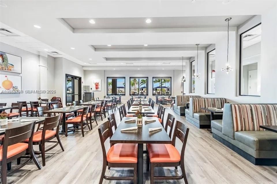 10922 Southwest Meandering Mile Road, Unit 10922 Port St. Lucie, FL 34987 - Photo 55 of 56 a view of a dining room and livingroom with lots of furniture and wooden floor