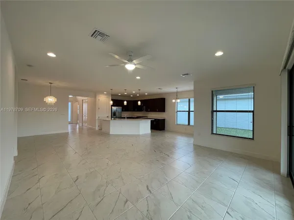 a large kitchen with stainless steel appliances a large counter top a stove and a refrigerator