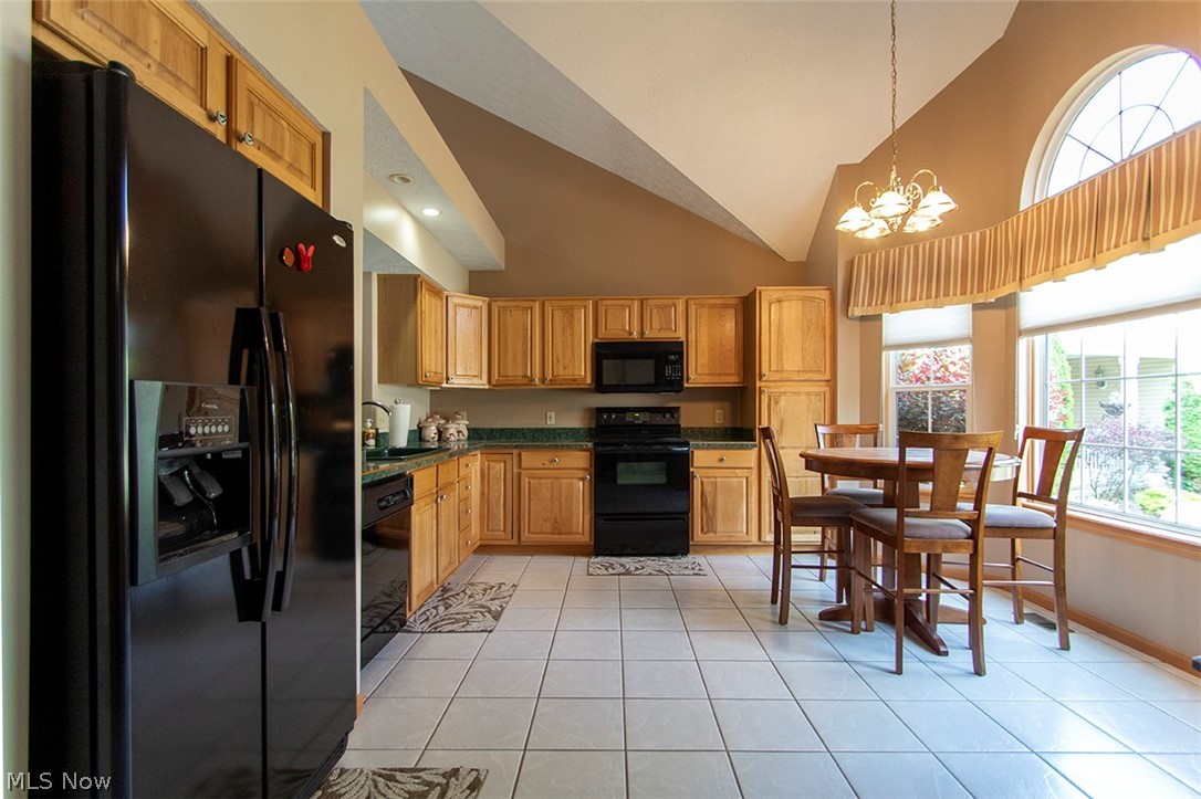 4902 Foote Road, Unit 21 Medina, OH 44256 - Photo 2 of 34 Kitchen featuring light tile flooring, decorative light fixtures, black appliances, high vaulted ceiling, and sink