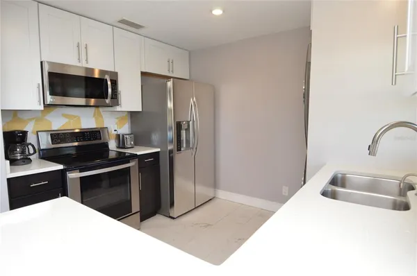 a living room with furniture a flat screen tv and a lamp