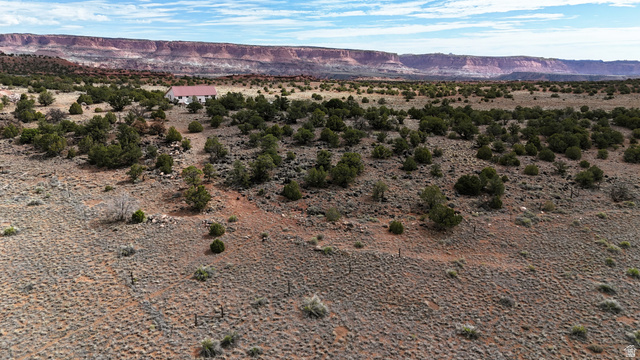 358 South Sky Drive Torrey, UT 84775 - Photo 73 of 82 Expansive desert landscape with a distant residence featuring a red-hued roof