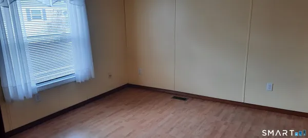 a view of a room with wooden floor and a window