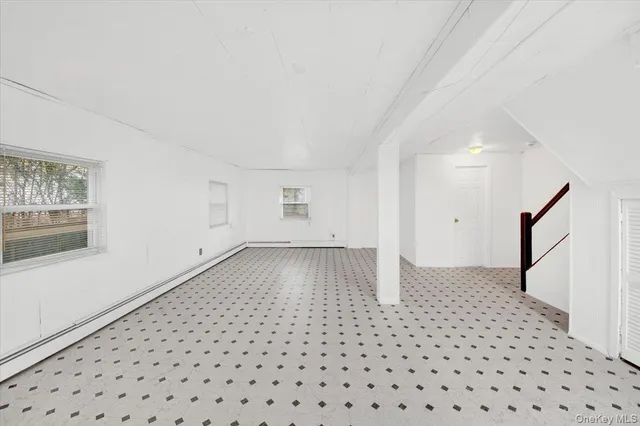 a view of a big room with wooden floor and windows
