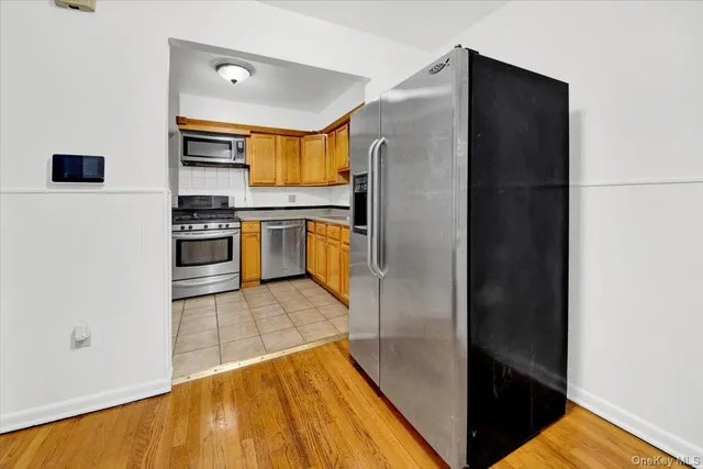 a kitchen with stainless steel appliances granite countertop a refrigerator and a stove top oven