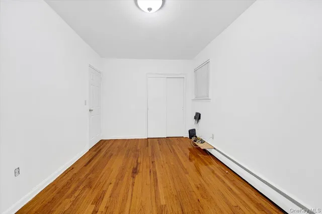 a view of a room with wooden floor and white walls