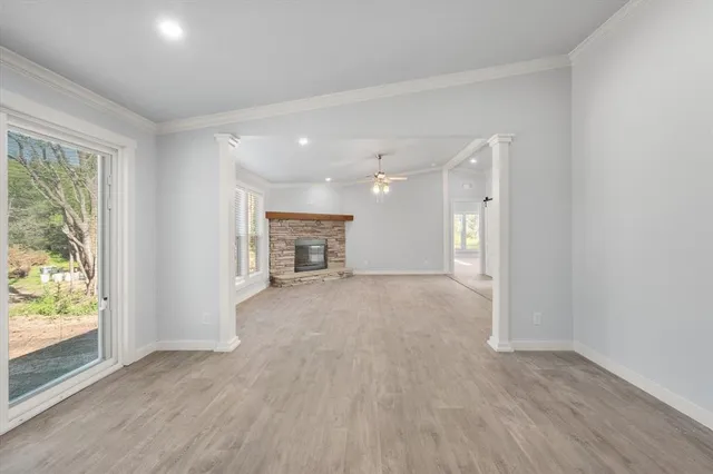 an empty room with wooden floor cabinet and windows
