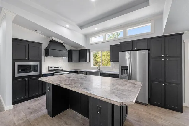a kitchen with stainless steel appliances granite countertop a sink refrigerator and microwave