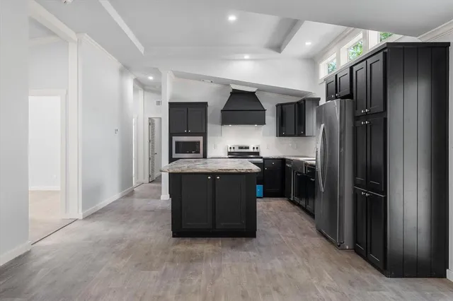 a kitchen with stainless steel appliances granite countertop a refrigerator and a sink