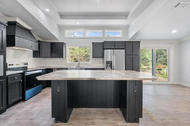 a kitchen with stainless steel appliances granite countertop a sink stove and refrigerator