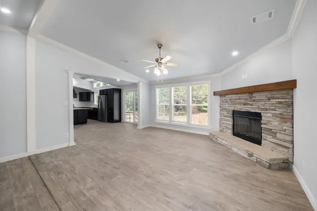 a view of an empty room with a fireplace and a window