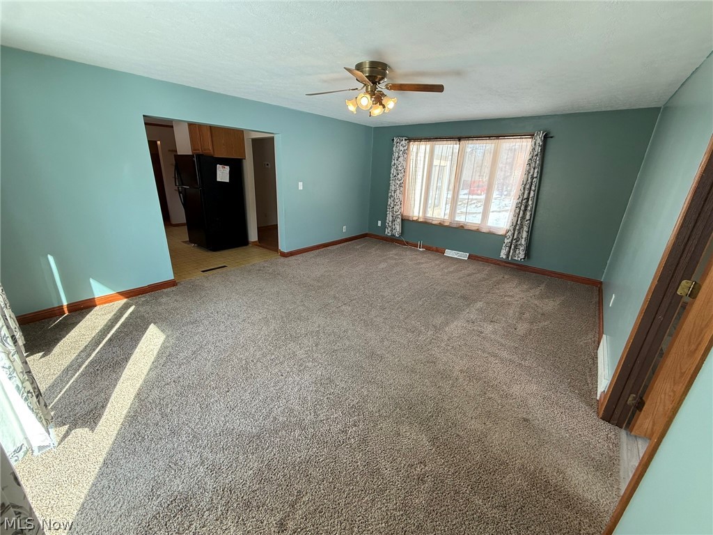 6784 Old Zoarville Road Northeast Dover, OH 44622 - Photo 17 of 50 Unfurnished bedroom featuring freestanding refrigerator, carpet flooring, a spacious closet, and ceiling fan